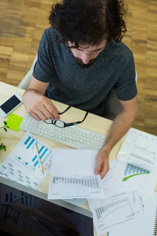 Accountant reviewing accounts receivable reports and financial charts at a desk