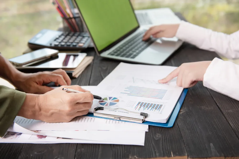Analysts reviewing charts and financial reports for a QuickBooks client case study