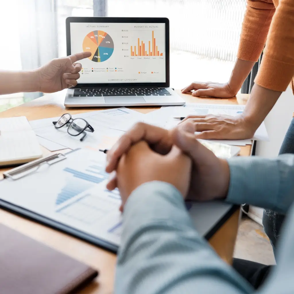 Financial consultants reviewing budget charts and pie graphs on a laptop screen