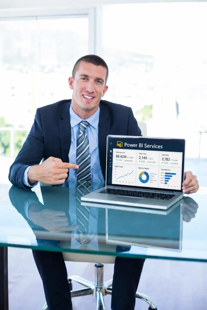 Man in suit pointing at laptop showing Power BI Services dashboard in modern office