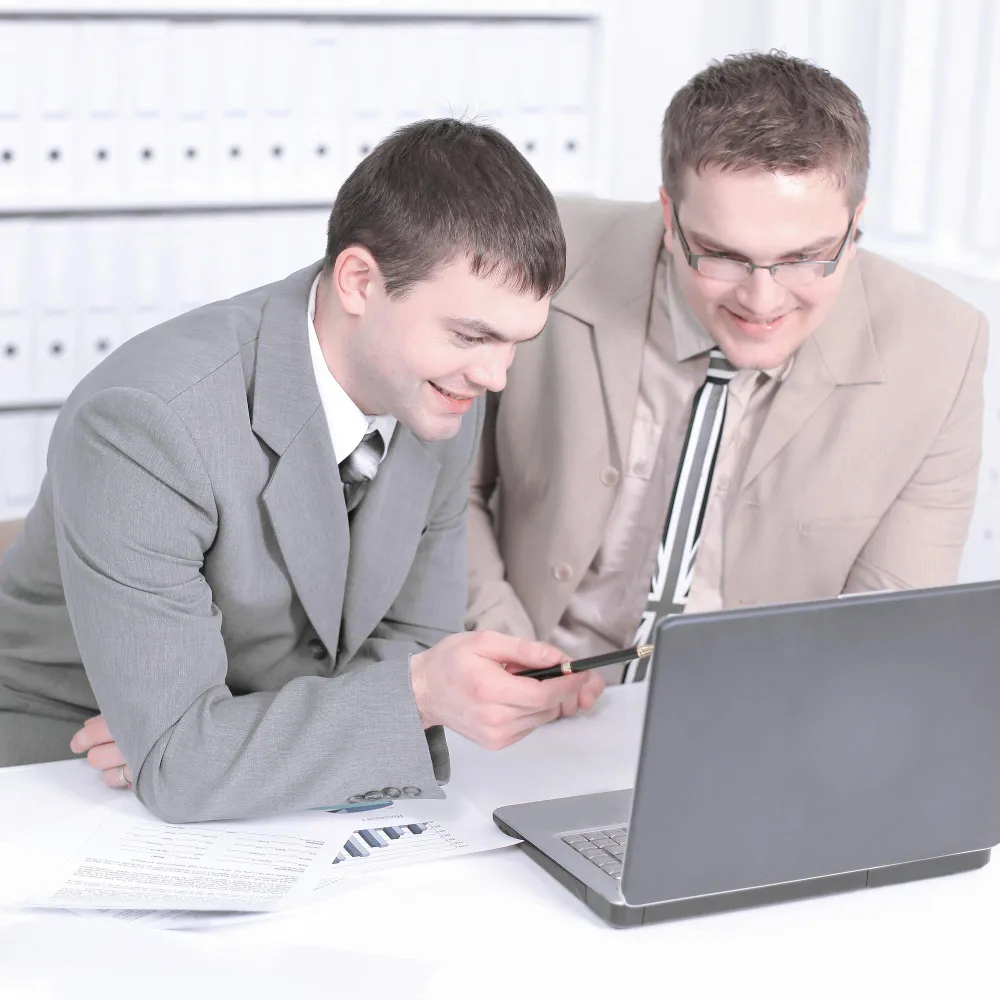 Two accountants reviewing financial data on a laptop for QuickBooks setup services