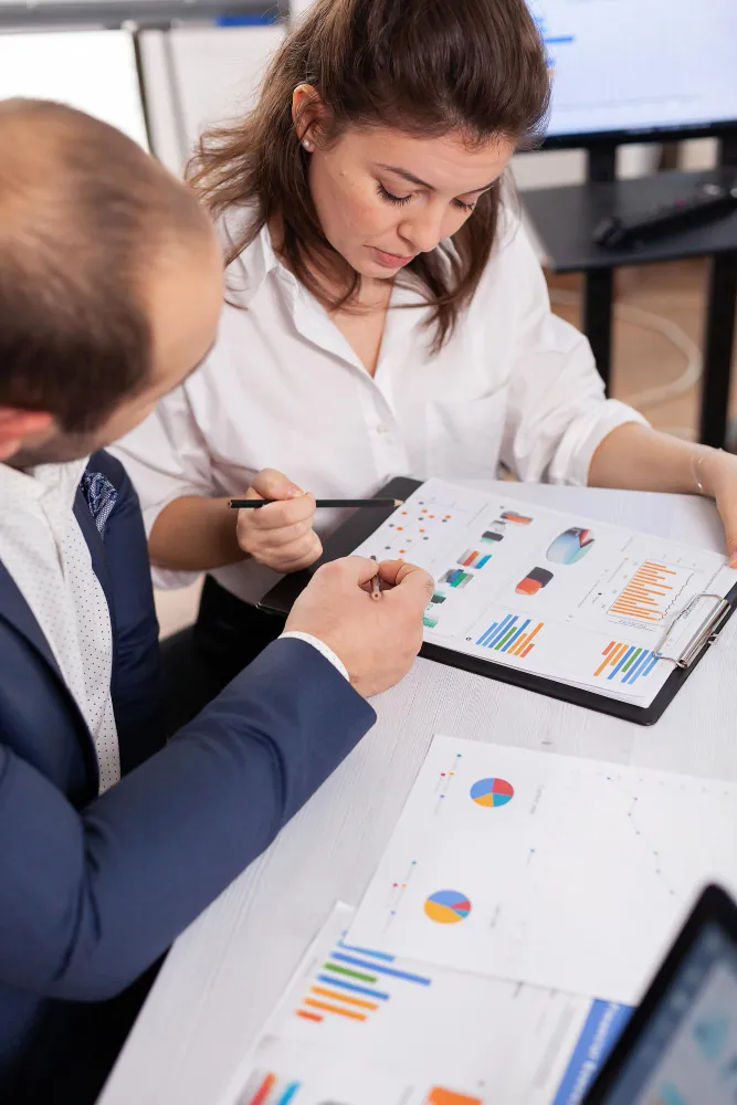 Two financial experts reviewing performance metrics and charts for fractional CFO services