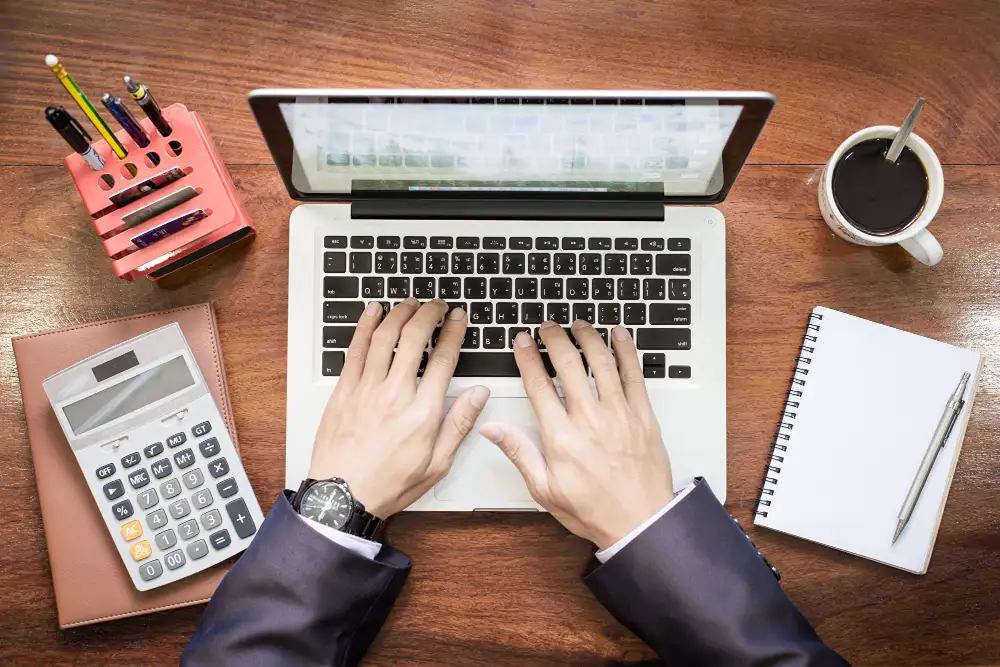 Professional-accountant-setting-up-QuickBooks-on-a-laptop-with-a-calculator-notepad
